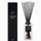 A clear glass reed diffuser from the Flowers on Norton St brand, labeled "Sohum Fragrance Diffuser," with black natural fiber reeds delivers a lovely scent, elegantly positioned next to its matching black box packaging.