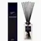 A stylish black bottle of the Sohum Fragrance Diffuser, by Flowers on Norton St, featuring a fine fragrance, is displayed alongside its matching rectangular box. Both showcase sleek black labels. Natural fibre reeds elegantly fan out from the top of the bottle, enhancing its sophisticated allure.
