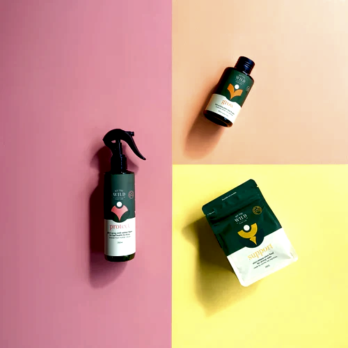A flat lay photograph features the Plant Lovers Gift Set from FlowersonNortonSt, with three skincare products in green and white packaging that evoke a plant care theme, arranged against a vibrant pink and yellow background. On the left is a spray bottle that resembles pest spray, while the pouch is positioned at the bottom right and a bottle sits at the top right.