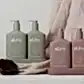 Two sets from the AL.IVE BODY | Earth Collection Duos by Flowers on Norton St are showcased, featuring cruelty-free, vegan hand and body lotions in sage green labeled "Green Pepper & Lotus" and in mauve labeled "Blueberry Bloom & Boronia." They are elegantly displayed on a soft cloth with a decorative brown pod nearby.