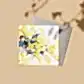 The Native Botanical Greeting Card by Flowers on Norton St features an abstract watercolor design with yellow, blue, and white splashes on a neutral background. Paired with a gray envelope, it captures the shadow of a plant dancing across its surface.