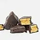 FlowersonNortonSt Whisk & Pin Honey Crunch Rocks, coated in dark chocolate, are arranged on a white background, with some pieces showcasing the crunchy honeycomb infused with Blue Mountains Honey inside.