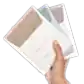A hand holds three packets of "Body Scrub to Mask" from Flowers on Norton St, featuring a minimalist design in light brown, blue, and white that emphasizes natural skincare for softening and soothing the skin.