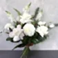 Introducing the Cream Classic Mixed Flowers by FlowersonNortonSt—a sophisticated arrangement of white and cream roses, dahlias, and snapdragons, artfully accented with striking greenery against a textured grey backdrop.