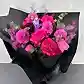 Introducing the Hot Pink Pop Mixed Flower Bouquet by Flowers on Norton St: a stunning arrangement featuring vibrant hot pink hues and seasonal blooms in shades of purple and red. Beautiful roses and dahlias are elegantly wrapped in black paper with lush green leaves, all set against a light gray background.