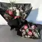 Displayed against a light gray background, two elegant bouquets from Flowers on Norton St's Little Native Bunch 2024 feature pink and white protea flowers accented with eucalyptus leaves and delicate greenery, all wrapped in black paper.