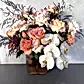 The Peaches + Cream Mixed Flower Vase by Flowers on Norton St includes pale pink roses, white Cloud Moth Orchids, and peach blooms. Enhanced with dark, feathery leaves, it rests elegantly against a light gray backdrop.