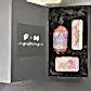 A sophisticated gift box labeled "Flowers on Norton St" presents the Royal Botanical Gardens Fragrance Collection, featuring a lavish bottle of lavender and rosemary hand wash, two complementary soap bars, and a rich hand cream. The set is elegantly arranged in black shredded paper, with the option of same-day delivery for an added touch of luxury whenever desired.