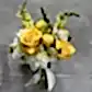 The Lovely Vintage Vases by FlowersonNortonSt, featuring bright yellow roses, yellow billy balls, white chrysanthemums, and snapdragons tied with a white ribbon, create an elegant table centerpiece against a gray background.
