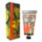 The image shows a tube of KEW Hand Cream by Flowers on Norton St, nestled beside its decorative box. As part of the Kew Royal Botanical Gardens floral collection, the packaging features intricate botanical illustrations of fruits and a butterfly.