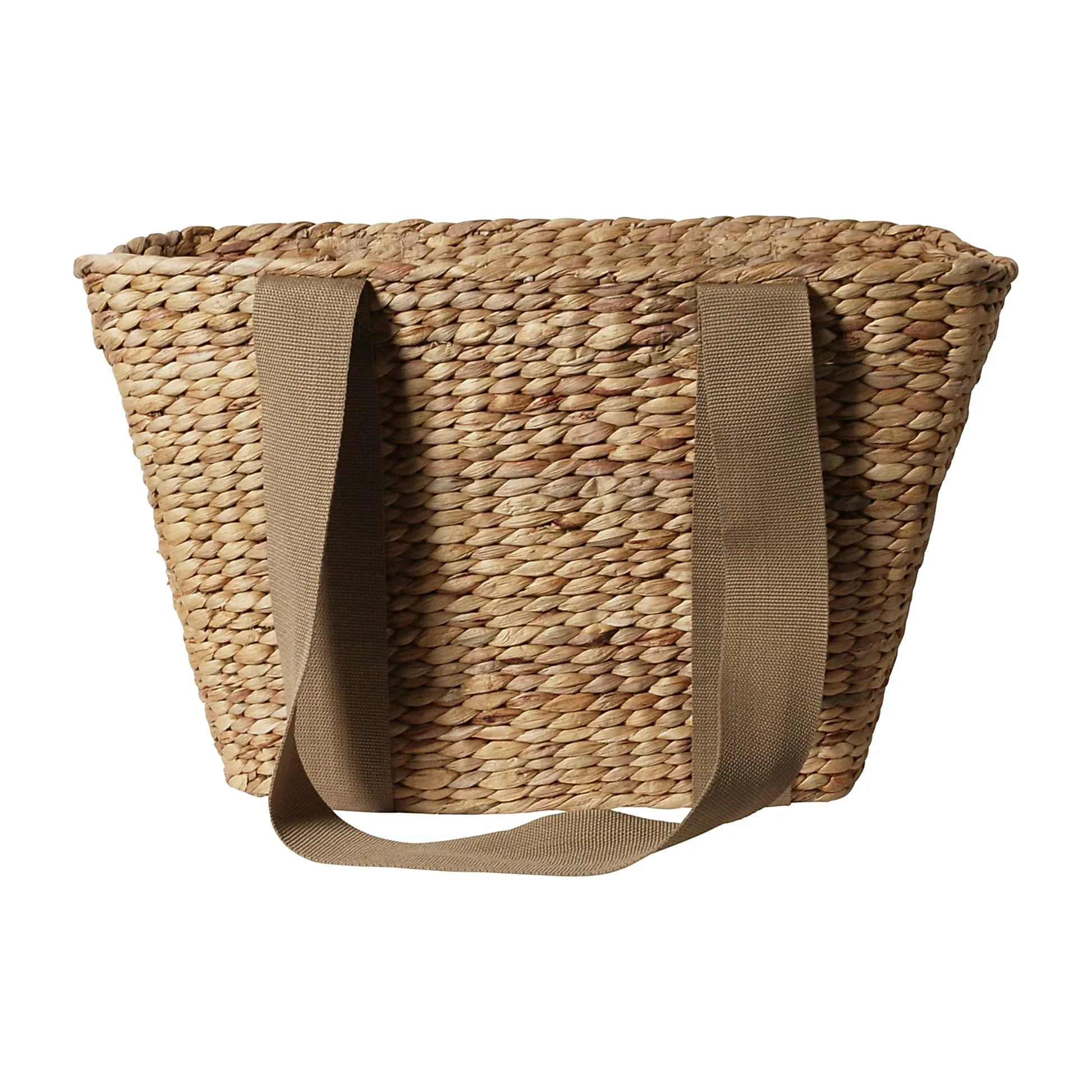 The Journey Tote Bag by Flowers on Norton St is a hand-woven straw tote featuring two wide beige shoulder straps that highlight its textured, natural straw appearance. These straps are attached at the top of this spacious, open design, reminiscent of a water hyacinth basket.