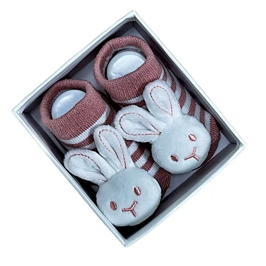 A pair of charming Baby Bunny Socks by Flowers on Norton St, featuring adorable pink and white stripes with cute bunny faces and ears, sits attractively in an open white box.