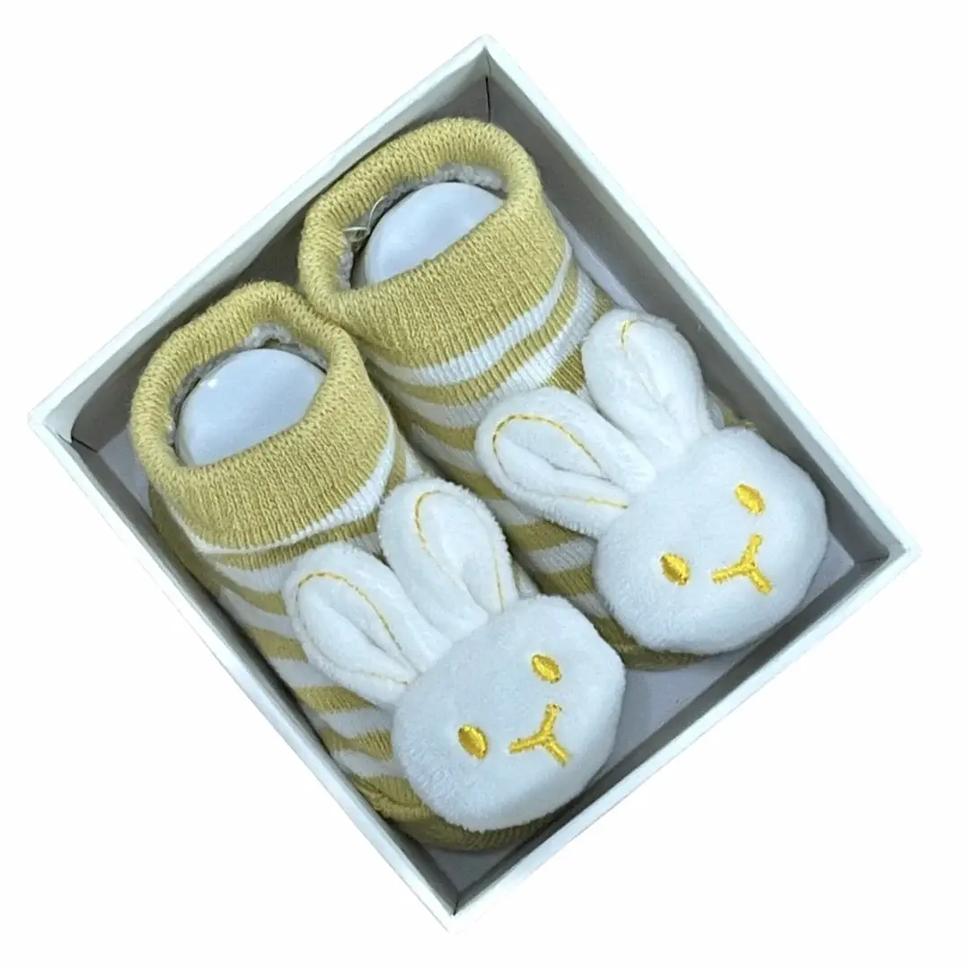 Tucked inside a box, the Baby Bunny Socks from Flowers on Norton St exude cuteness with their yellow and white stripes and plush white bunny faces showcasing embroidered yellow eyes and noses.
