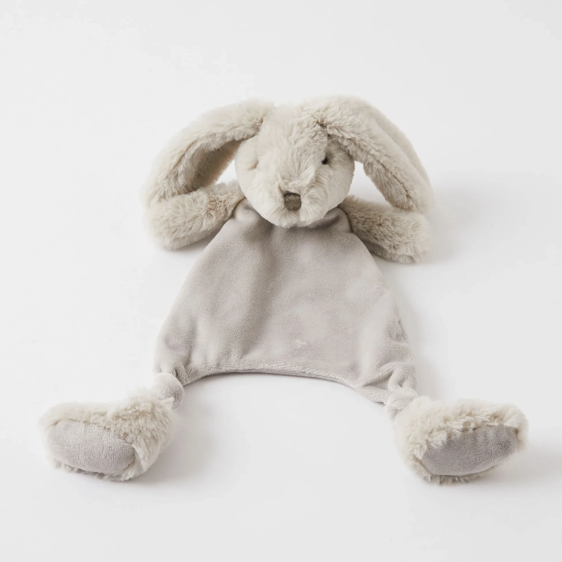 The Jiggle & Giggle Bunny Comforter by FlowersonNortonSt rests on a white background. With its soft, grey plush texture, floppy ears, and simple face, this ultra-soft bunny soother lacks arms or legs and features a small, flat body ending in rounded feet. It's the ideal comfort item for teething babies needing gentle solace.