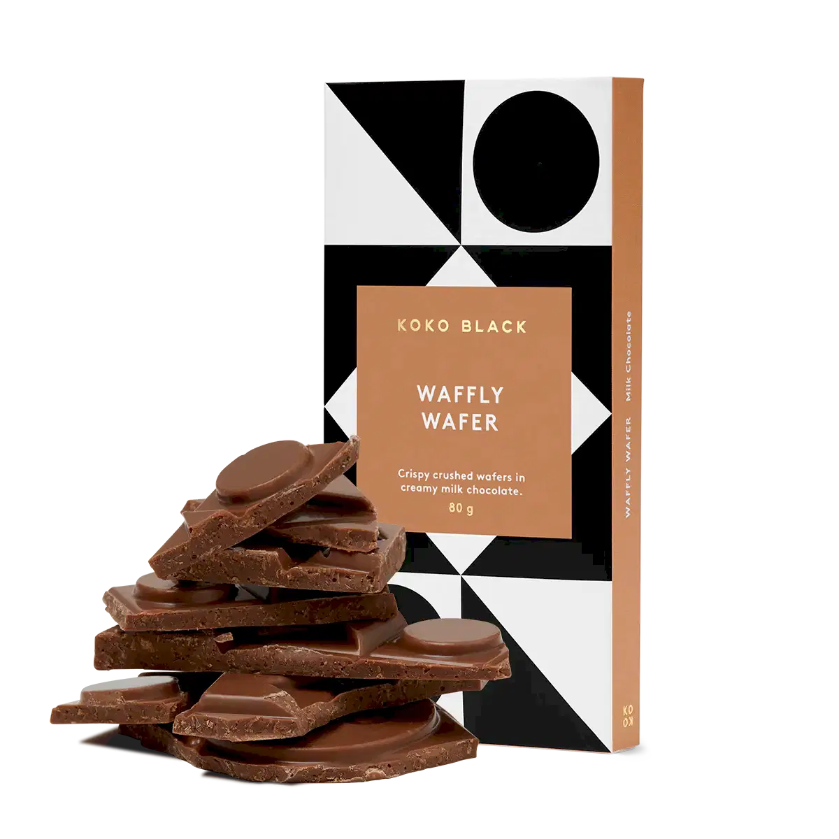 A FlowersonNortonSt Koko Black Chocolate Block wrapped in geometric patterned packaging is displayed beside a stack of broken chocolate pieces. Made with sustainably sourced cocoa, the package notes that it contains crispy crushed wafers in creamy milk chocolate.