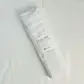 A soft Muslin Wrap from FlowersonNortonSt, rolled up with a label indicating it's 100% cotton, perfect for baby wrapping. The background is a plain white surface.
