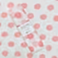 A Muslin Wrap from FlowersonNortonSt, adorned with a charming pink polka dot pattern, is rolled up and held together by a label. The background also features this delightful design, making it perfect for baby wrapping.